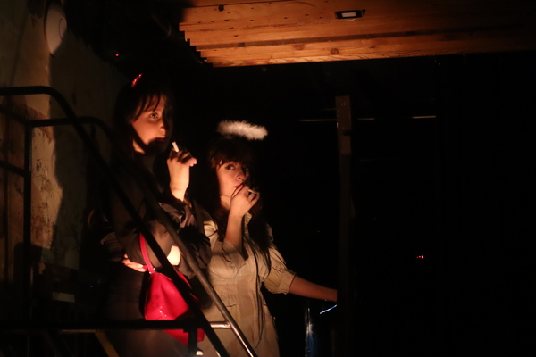 two characters smoking in intense orange light coming from below