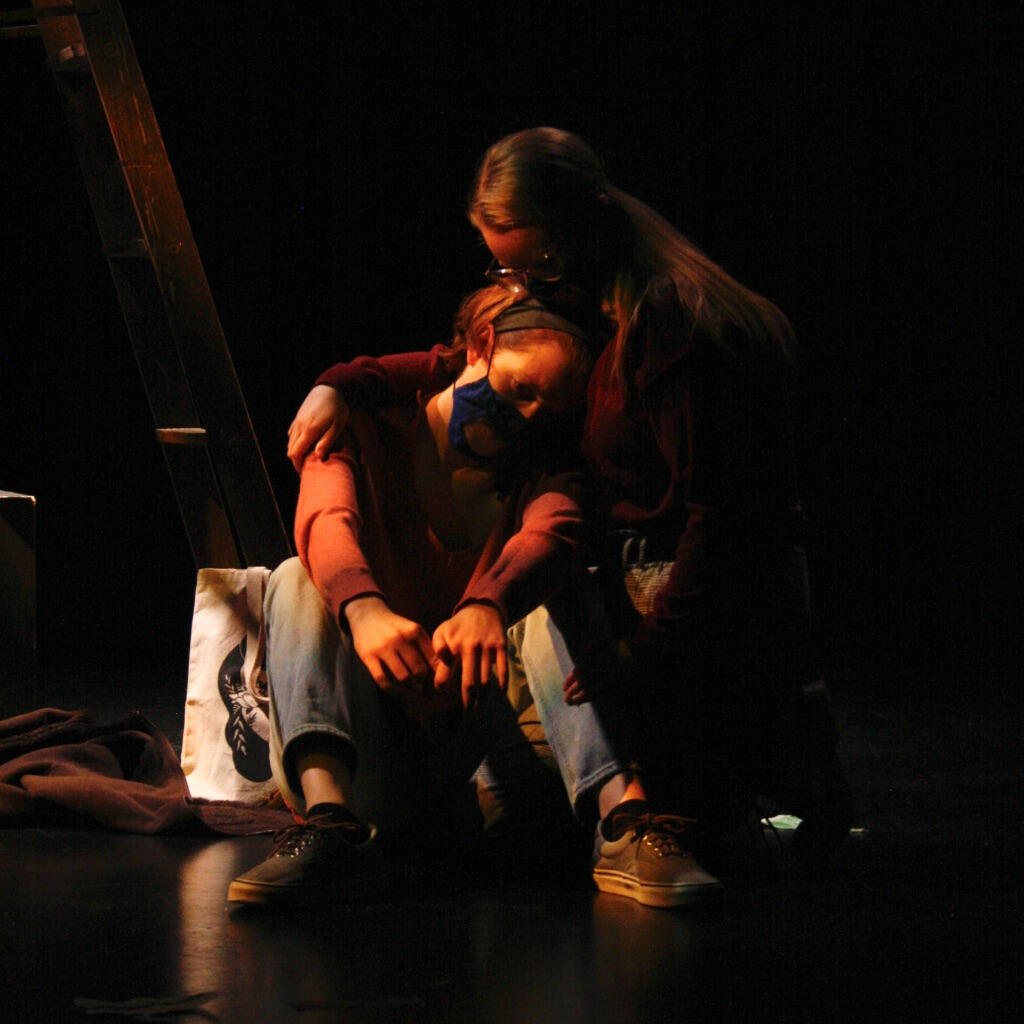 two characters hug in dim light in Exit 7